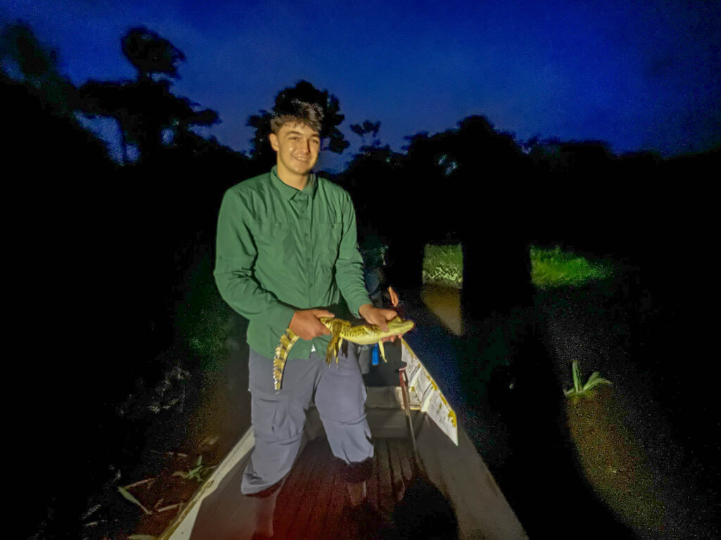 Erik holding a caiman in our boat
