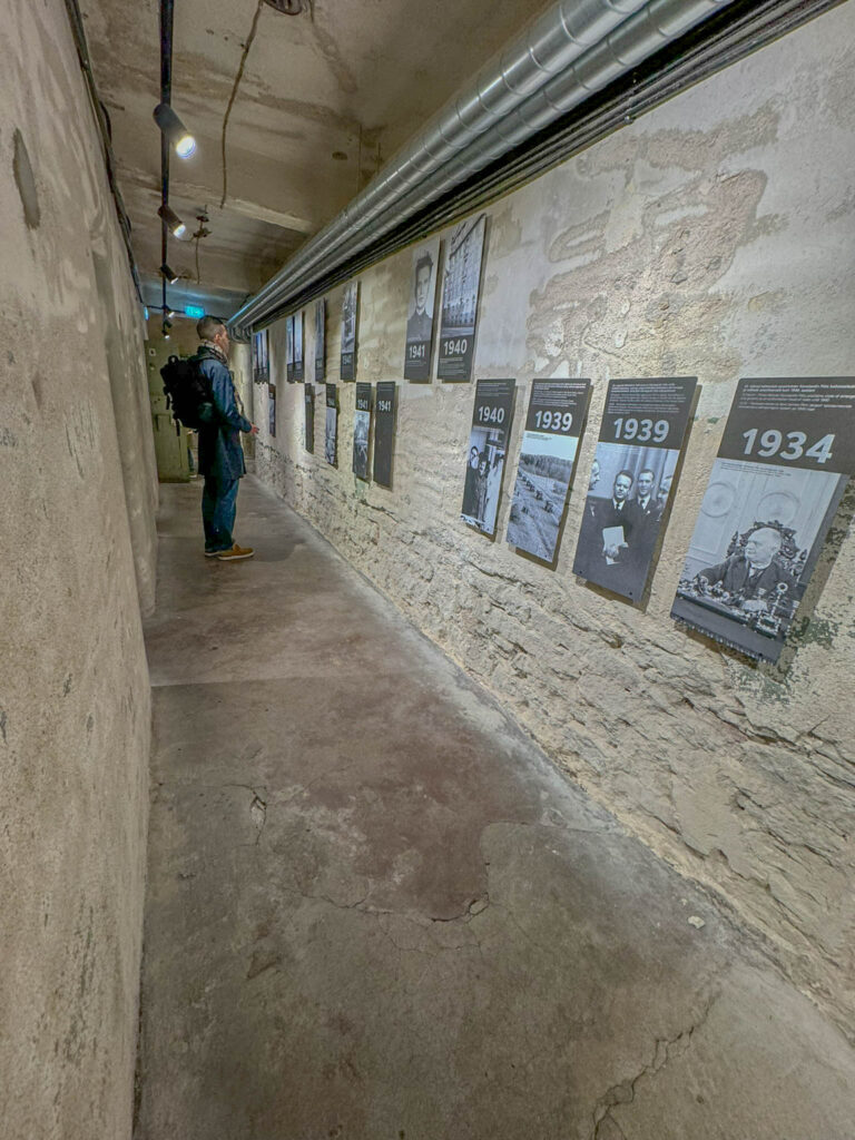 A long corridor lined with prison cells showcases photos and artifacts, providing a glimpse into life inside the KGB prison in Tallinn, Estonia.