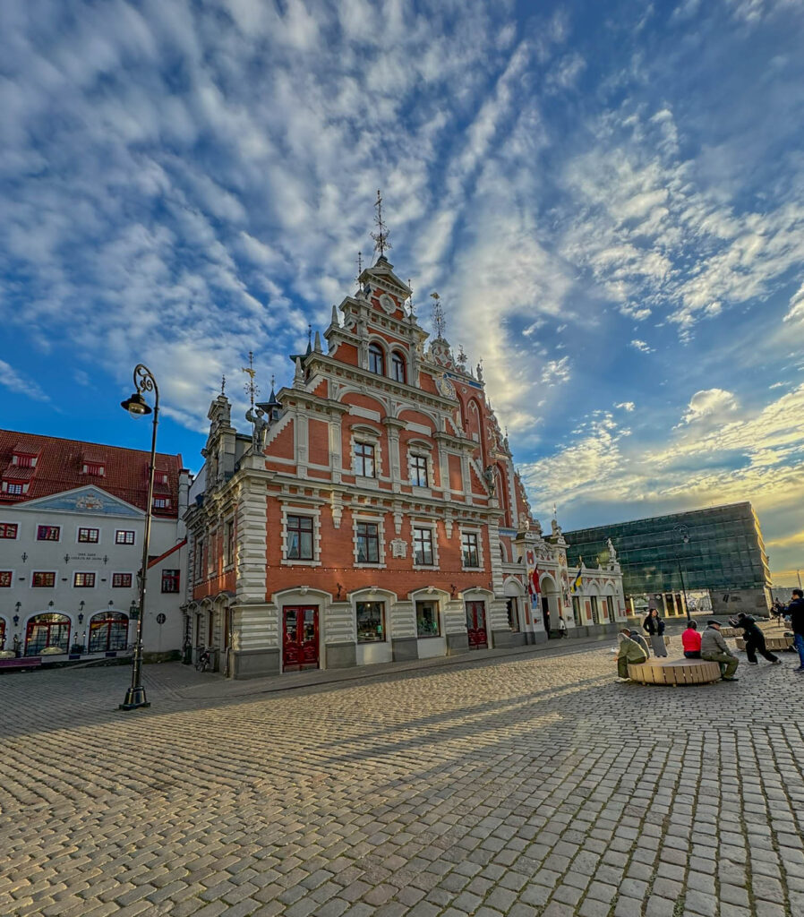 Here's another view of the House of the Black Heads. You're probably asking yourself, what's a "black head"? A Black Head refers to someone who belonged to the Brotherhood of Black Heads, a historic group made up of single merchants, shipowners, and international traders. The group took its name from St. Maurice, their patron saint. St. Maurice was a Black Christian martyr from Africa, honored throughout medieval Europe. He’s often shown as a warrior in armor with dark skin, symbolizing bravery and resilience. The Brotherhood chose his image as their emblem of protection and strength, which eventually inspired their name, the Black Heads.