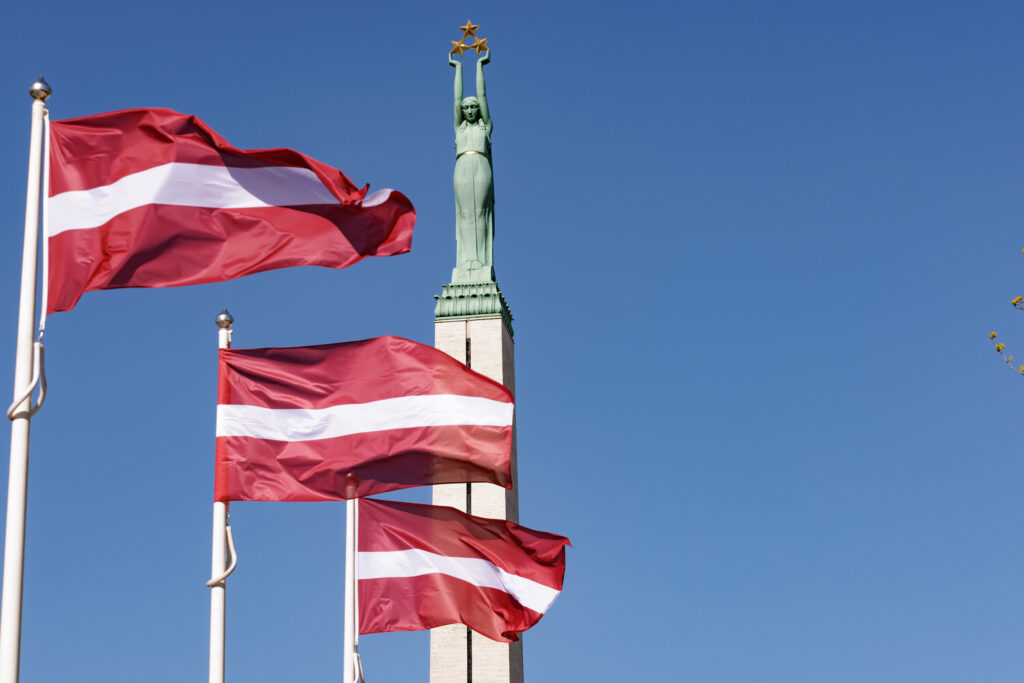 Latvia's flag flies in front of the National Freedom Monument in Riga, Latvia (Girts – stock.adobe.com)