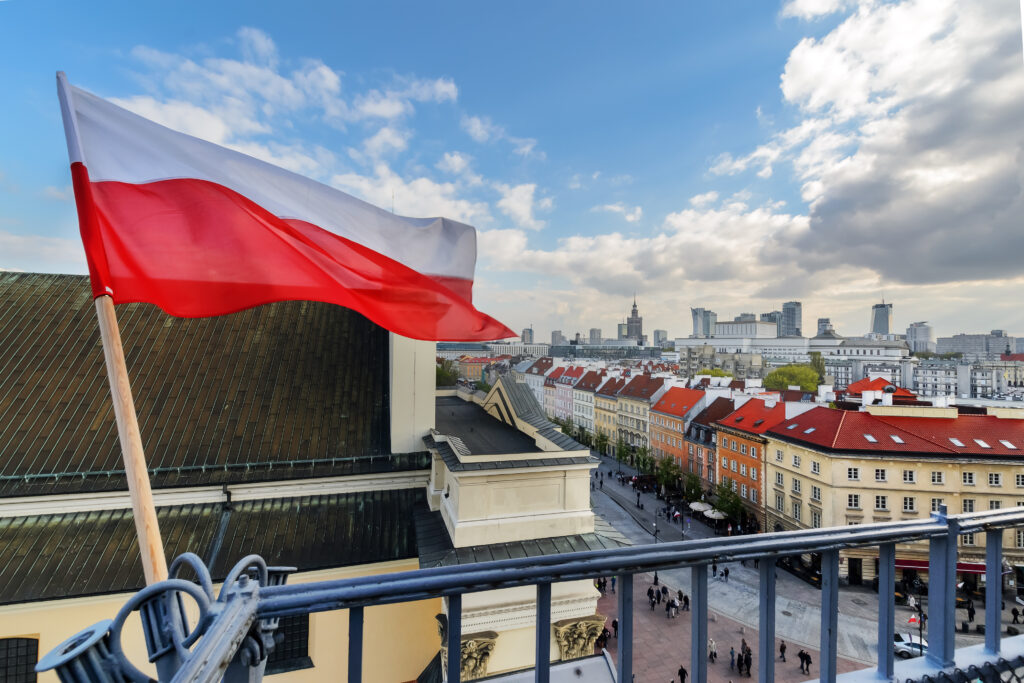 Poland flag with Warsaw in background (velishchuk, Adobe Stock Photo)