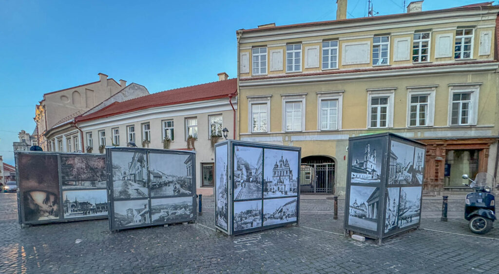 Strolling past an outdoor exhibit featuring vintage photos of Vilnius.