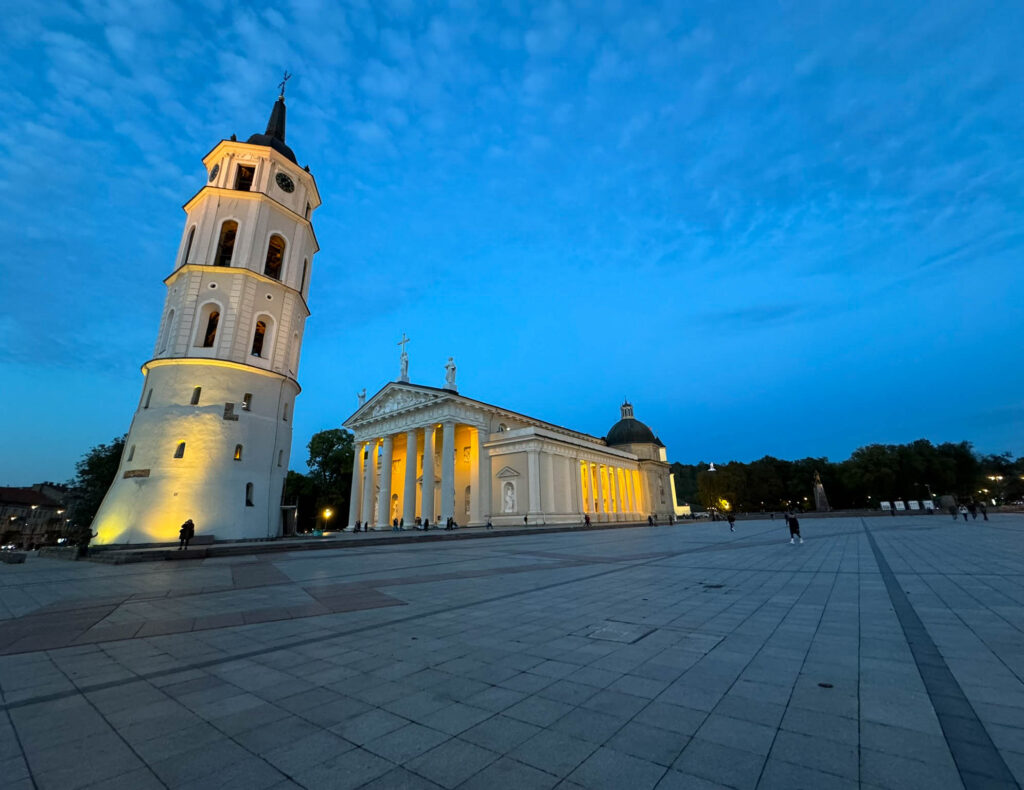 Vilnius Cathedral and its Bell Tower sit in Cathedral Square, Vilnius, Lithuania. The Bell Tower: Once part of the city's old defenses, it later became a bell tower. It's a standout landmark, separate from the cathedral. The Cathedral: Designed by Laurynas Gucevičius in the 18th century, it's a Neoclassical masterpiece and Lithuania's spiritual center. Inside, you'll find the Chapel of St. Casimir that was built in 1623–36 after Prince Casimir (1458–1484) was canonized as saint.