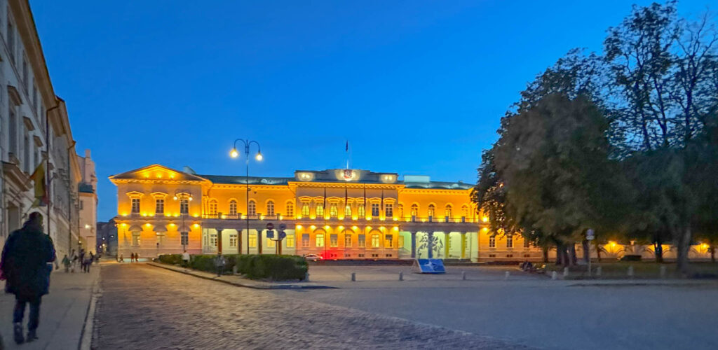 The Presidential Palace in Vilnius, Lithuania, is the President's official home and workplace. Built in the 14th century as a bishop's residence, it got its Neoclassical look during 19th-century renovations. Over time, it hosted rulers like Lithuanian Grand Dukes and Russian governors. Today, it holds state events, ceremonies, and welcomes foreign leaders, with the Lithuanian flag and coat of arms proudly displayed.