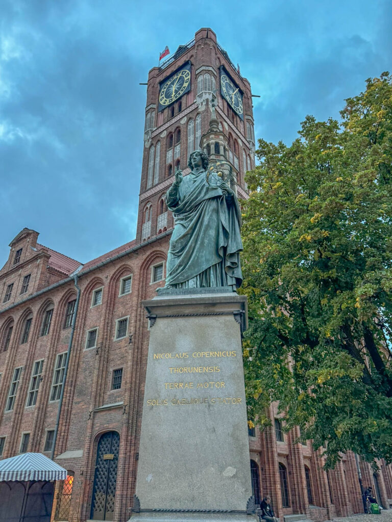 A closer look at the bronze statue of Nicolaus Copernicus in front of the Old Town Hall. It's been there since 1853, honoring the hometown guy who flipped our understanding of the solar system upside down. The inscription calls him the "Mover of the Earth, Stopper of the Sun and Sky." No big deal, right? Just a little reminder that one bold idea can change how we see everything.