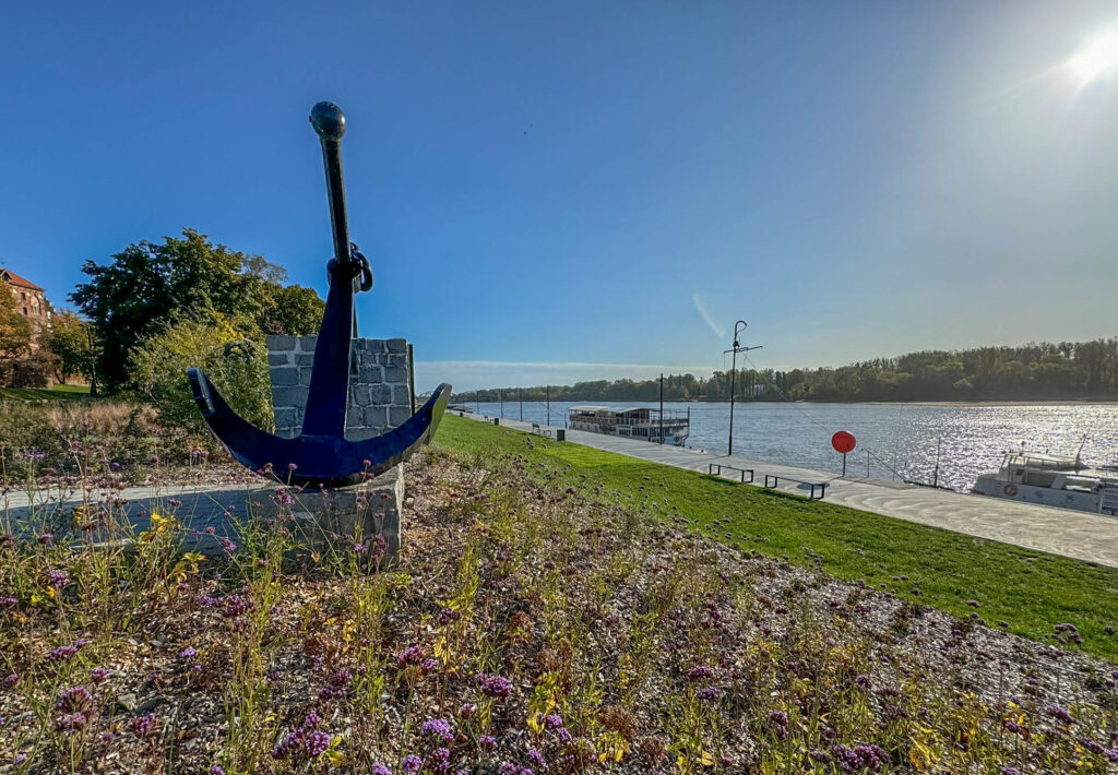 The sculpture shown in the image is the Anchor Monument, located by the Vistula River in Toruń, Poland. It stands as a tribute to the city's rich maritime and trade history, emphasizing Toruń's long-standing relationship with the river as an important route for transportation and commerce. The anchor symbolizes navigation, strength, and the city's legacy as a significant port and member of the Hanseatic League. The Hanseatic League was a powerful medieval trade and defense alliance of Northern European cities (13th–17th century), fostering economic dominance along the Baltic and North Seas, with cities like Toruń thriving as key trading hubs.