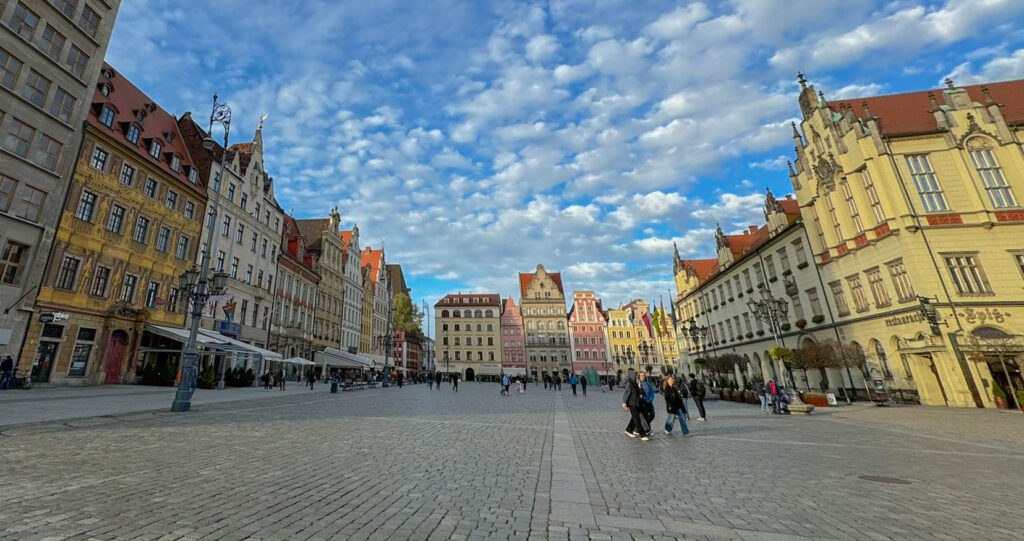 The colorful historic townhouses in Wrocław’s Market Square (Rynek) showcase a mix of Gothic, Baroque, and Renaissance architecture, carefully restored after World War II. Once home to wealthy merchants, these vibrant buildings now house cafes, restaurants, and shops, adding to the square’s lively atmosphere.