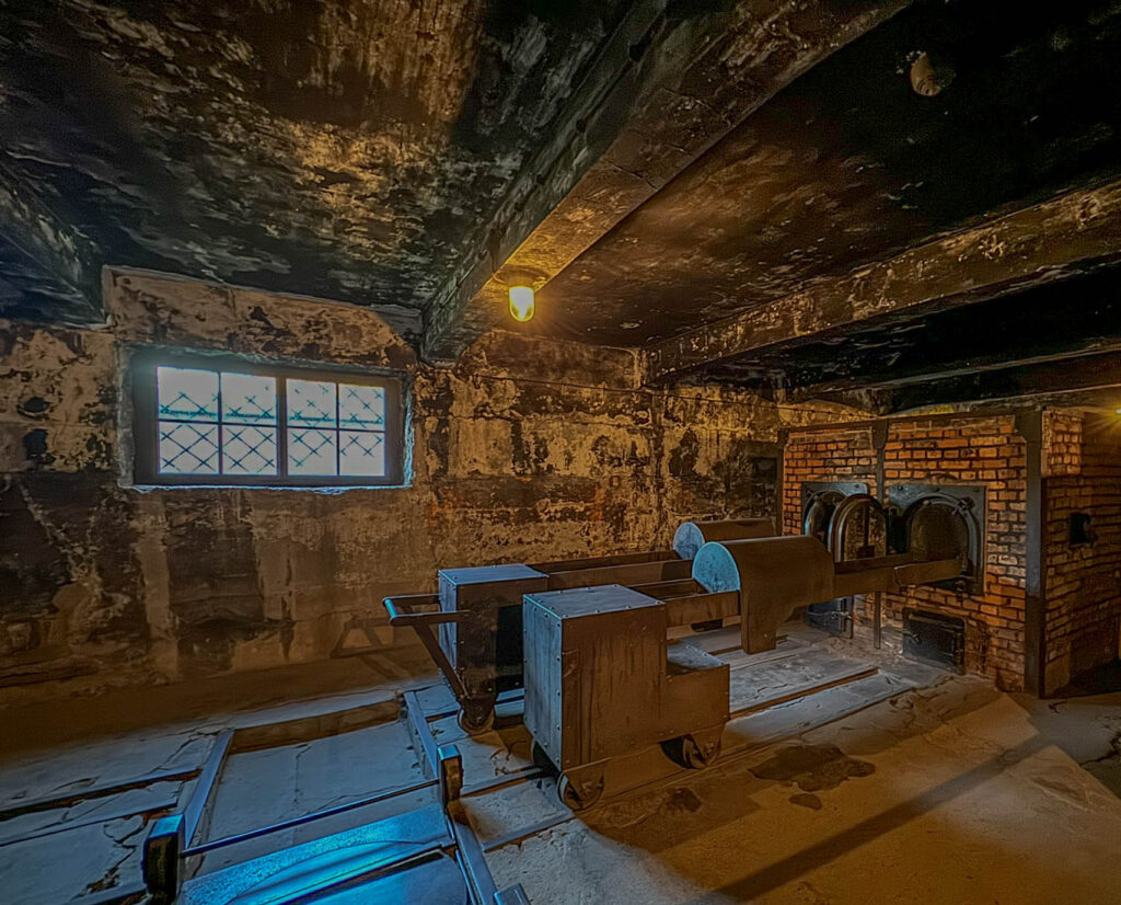 The crematorium ovens inside Auschwitz I, located next to the gas chamber where victims were executed. The brick structure and open iron doors reveal the grim function of these furnaces, which were used by the Nazis to dispose of bodies after mass killings.