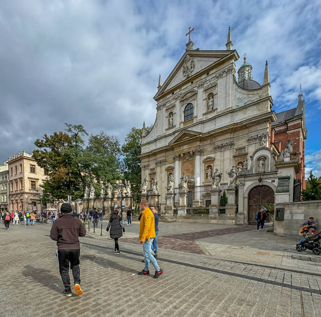 This building is the Church of Saints Peter and Paul (Kościół Świętych Apostołów Piotra i Pawła) in Kraków, Poland. It is a Baroque-style church built in the early 17th century by the Jesuits, known for its grand façade and a row of statues of the 12 apostles in front. Located on Grodzka Street, it is one of Kraków’s most famous churches and features an elaborate interior, as well as a Foucault’s pendulum, used to demonstrate Earth's rotation.