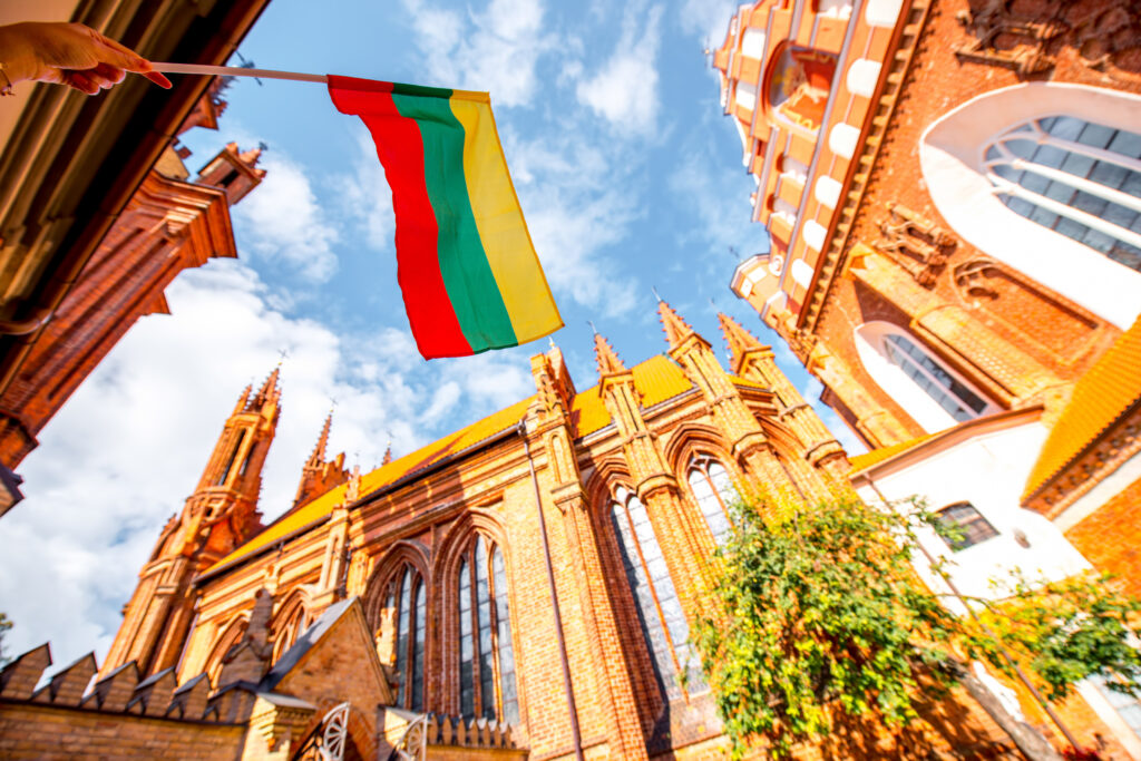 View of St. Anne's Catholic Church and Bernardine Church with the Lithuanian flag in the old town of Vilnius, Lithuania (rh2010 – stock.adobe.com).