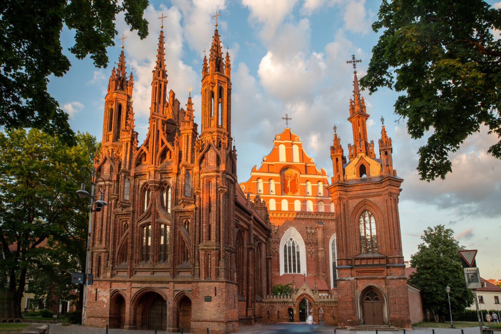 St. Anne's Catholic Church (left), bell tower (right), and The Church of St. Francis and St. Bernard, also known as Bernardine Church (middle) looming behind St. Anne's church in Vilnius (Marat Lala - stock.adobe.com)