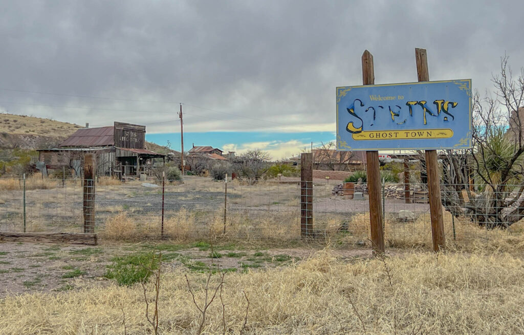 The entrance to Steins Ghost Town, nestled in the rugged terrain of southwestern New Mexico near the Arizona border, offers a glimpse into a once-thriving railroad stop turned eerie relic. Abandoned in the 1940s after the Southern Pacific Railroad shut down its operations, Steins became a private historical site—until tragedy struck. In 2011, longtime owner Larry Link was found shot to death on the property in an unsolved homicide that shocked the local community. Today, the faded buildings and weathered sign serve as a haunting reminder of both frontier history and a modern-day mystery.