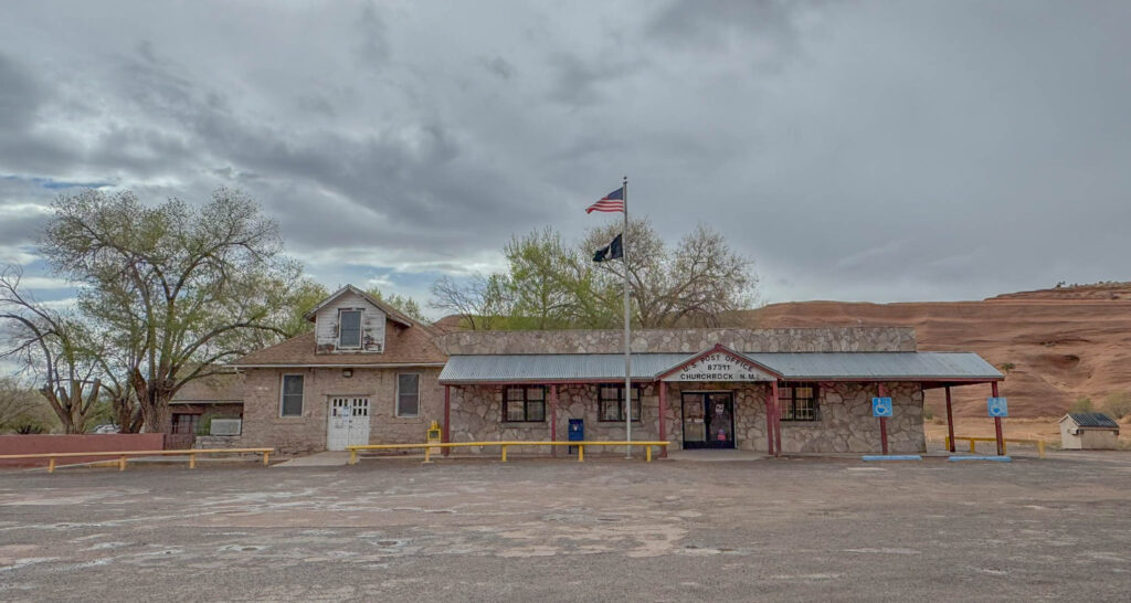 The Church Rock Post Office, quietly doing its job since the 1960s—tucked between red cliffs and slow-moving clouds. It’s the kind of place that doesn’t seem in a hurry to change, and that’s part of the appeal.