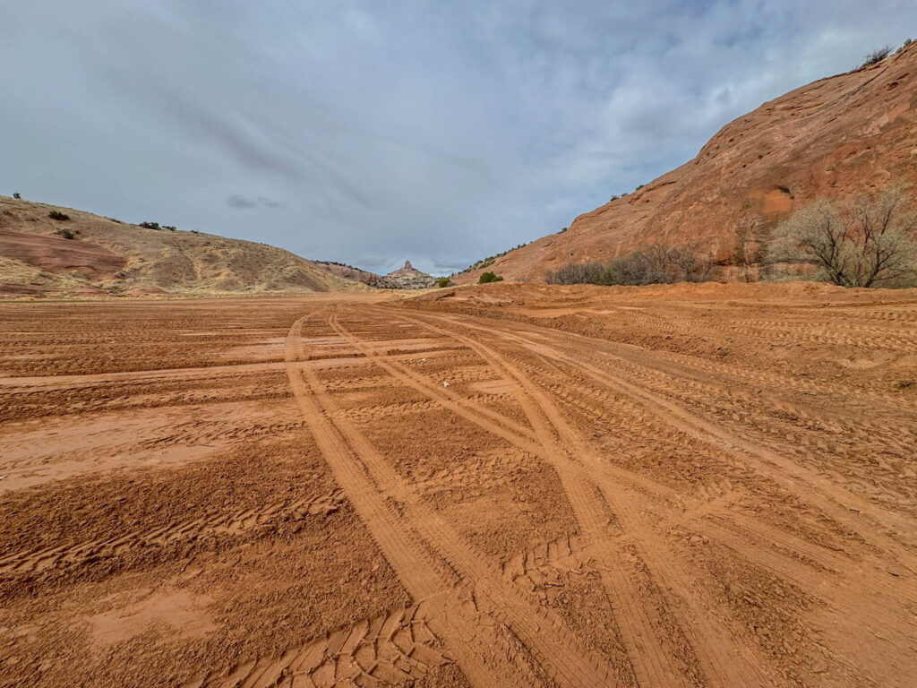 Before you even reach the official trailhead, you’ll cross a wide stretch of red earth—soft, sunbaked, and unmistakably New Mexico.