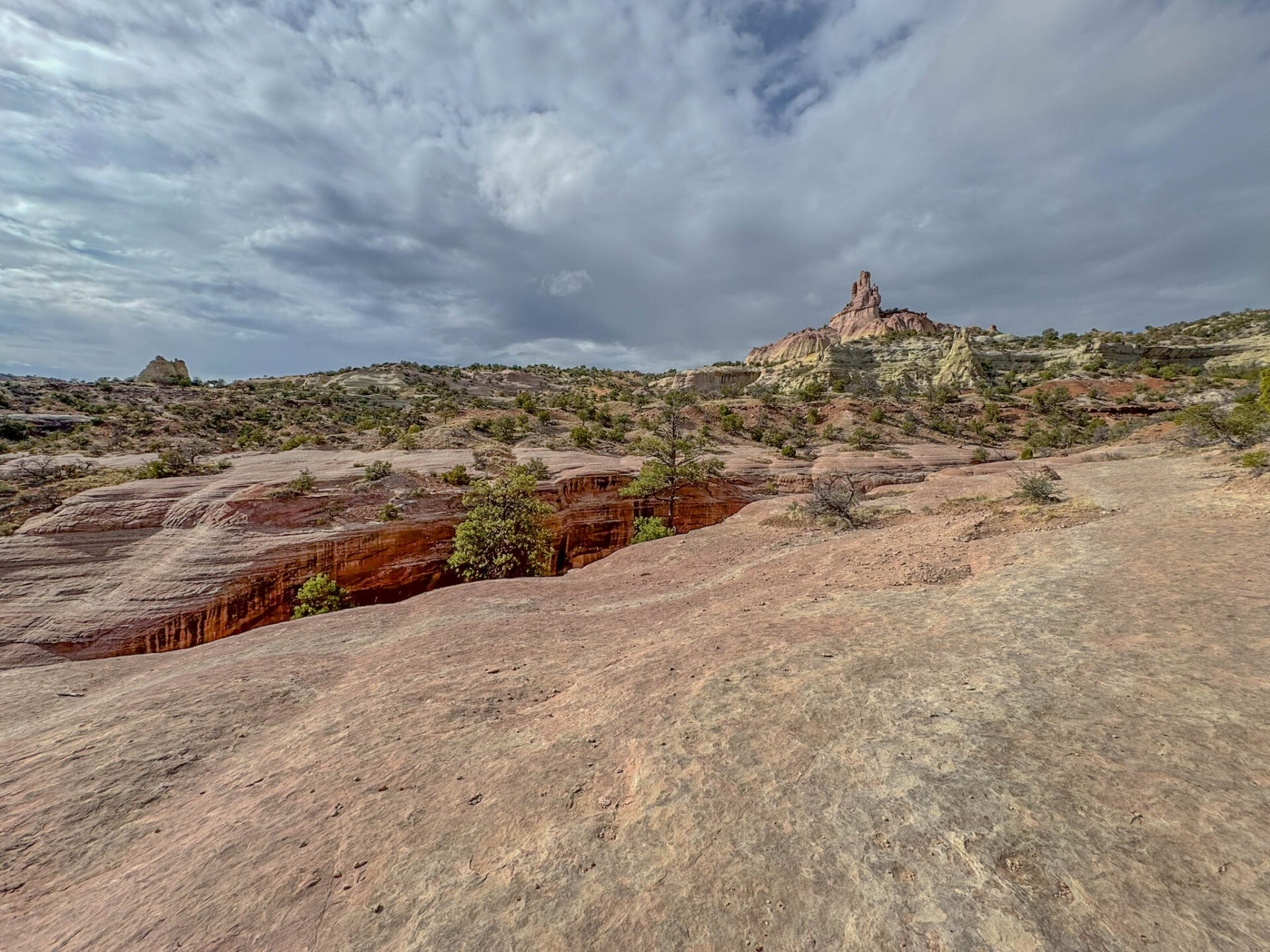 Another view of the unusual landscape along the Church Rock Trail—striped sandstone, scattered junipers, and that dramatic spire always waiting to steal the scene.
