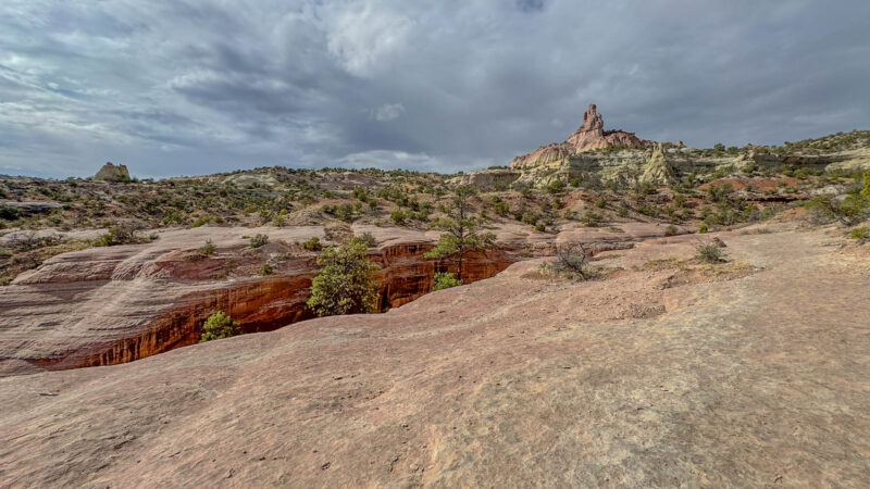 Another view of the unusual landscape along the Church Rock Trail—striped sandstone, scattered junipers, and that dramatic spire always waiting to steal the scene.