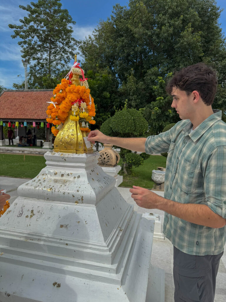 Pressing gold leaf onto the statue, trying not to mess it up.