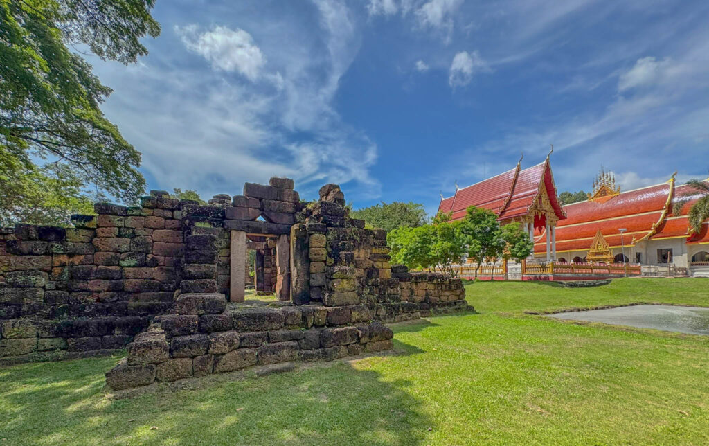 The old Khmer ruin sitting just steps away from a modern Thai temple.