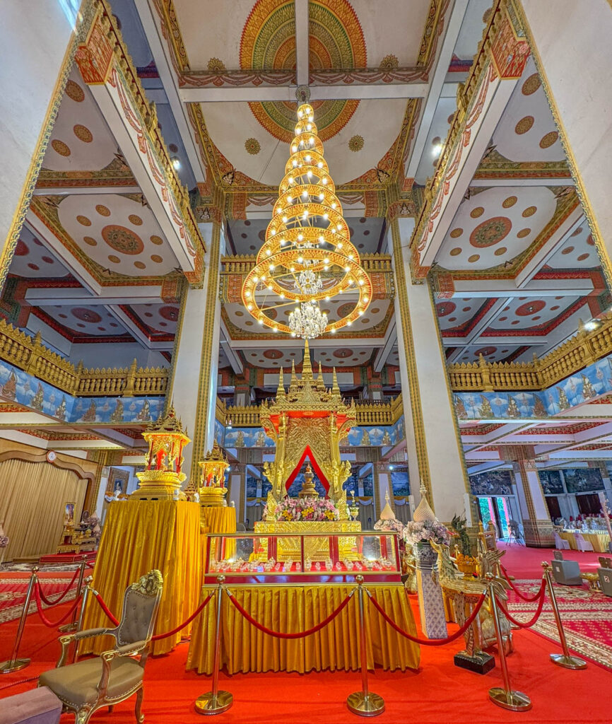 The main altar inside Wat Nong Wang, framed by a spiral chandelier and gold details in every direction.