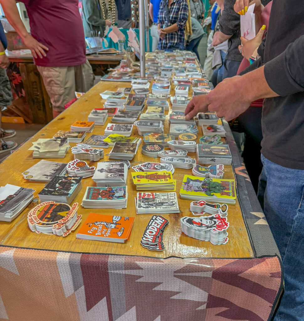 The vendor hall inside Tingley Coliseum mixed traditional artwork with modern Native artists, clothing, stickers, and pop culture references.