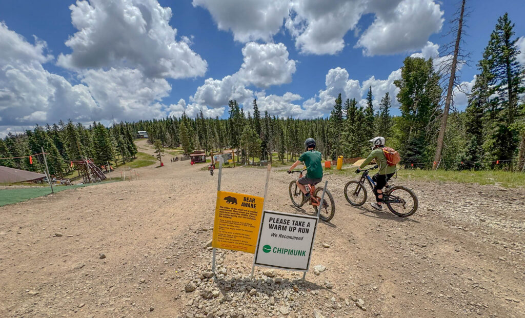 Mountain bikers prepare to head downhill from the summit of Angel Fire Bike Park.